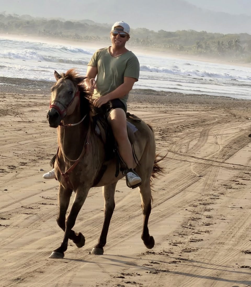 Chad Allen riding a horse along the beach